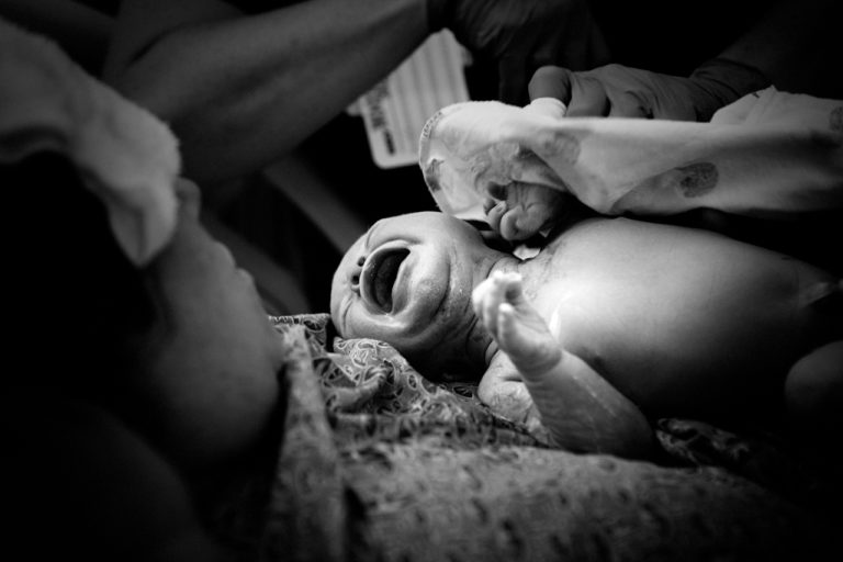 black and white birth image of a baby's first cry .