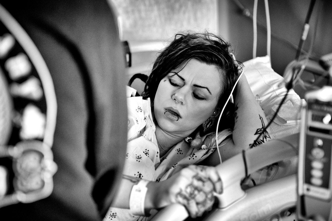 Image of a mother grabbing the rail of her bed during labor.