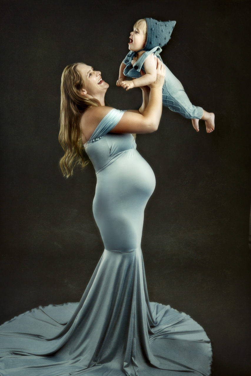 Maternity portrait of a mother to be holding her other son.