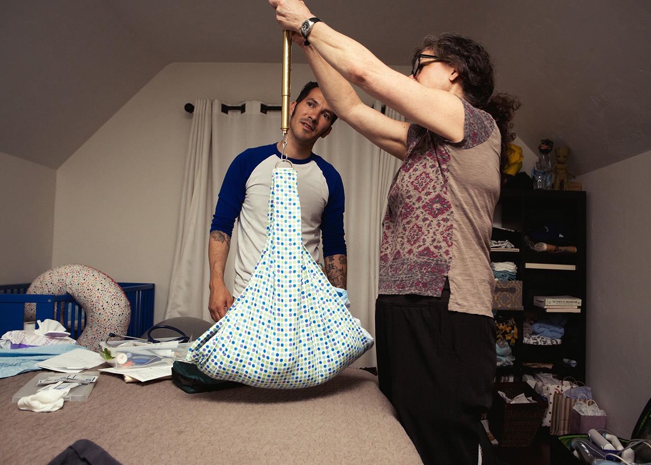 color birth photo of a midwife weighing a newborn at a home birth