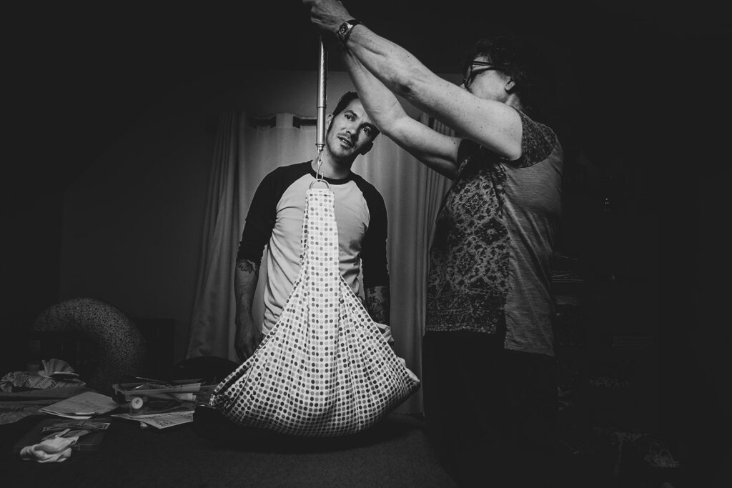 Los Angeles birth photography black and white Los angeles birth photography image of a midwife weighing a baby after a home water birth in North Hollywood