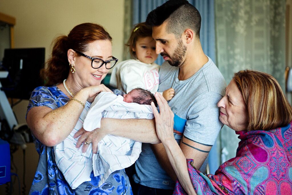 Los Angeles birth photography photo of the extended family meeting a new born baby at Adventist Health Glendale.