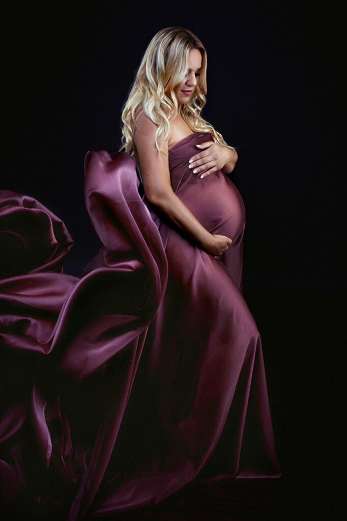 color maternity portrait of a blond woman wrapped in mauve material by Birth and Beauty