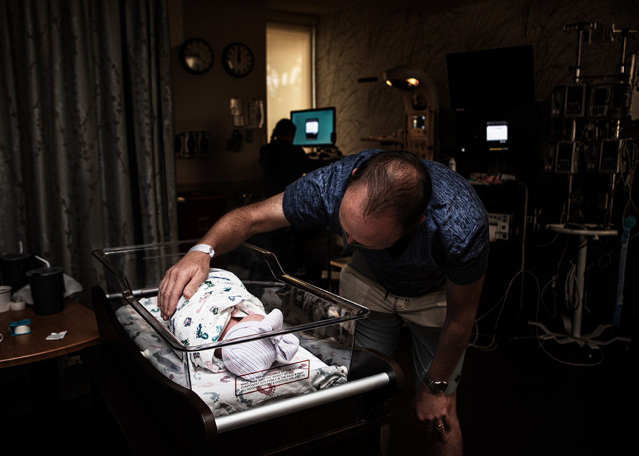 color birth photo of a dad meeting his newborn daughter at Scripps La Jolla