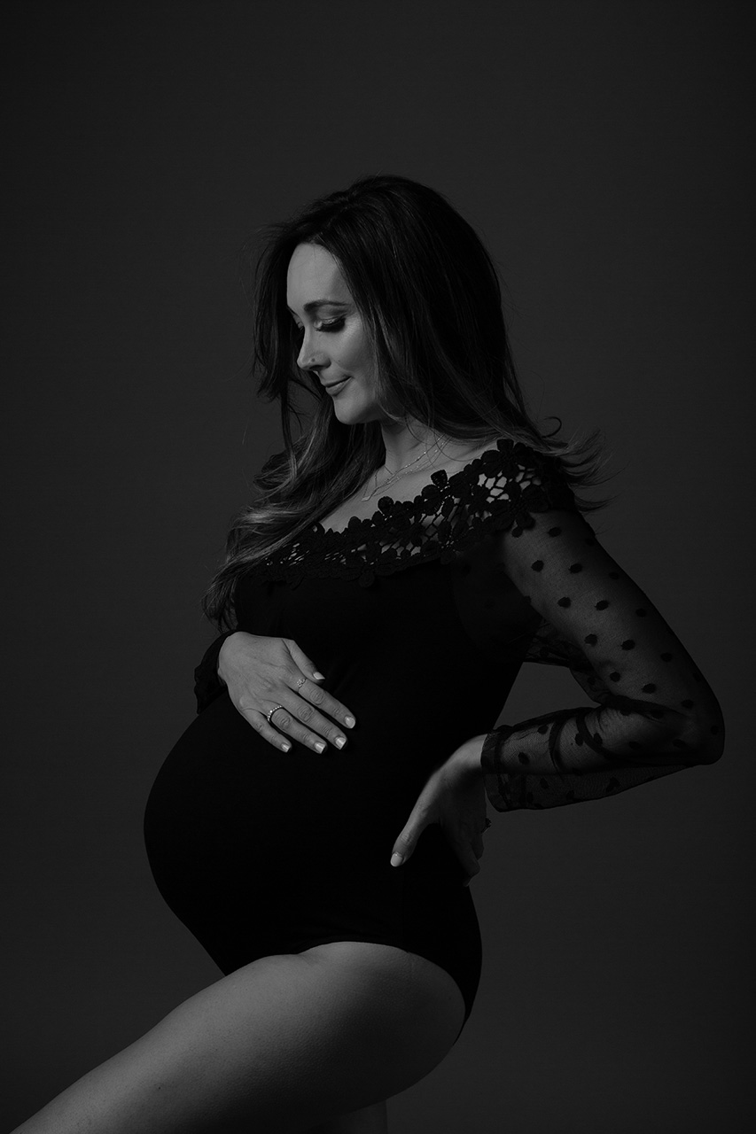 Black and white pregnancy portrait of a woman wearing a black bodysuit by Los Angeles maternity photographer, Leona Darnell
