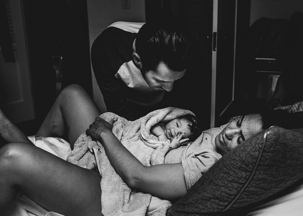 postpartum birth photo of a father looking at his newborn during a los angeles home birth.