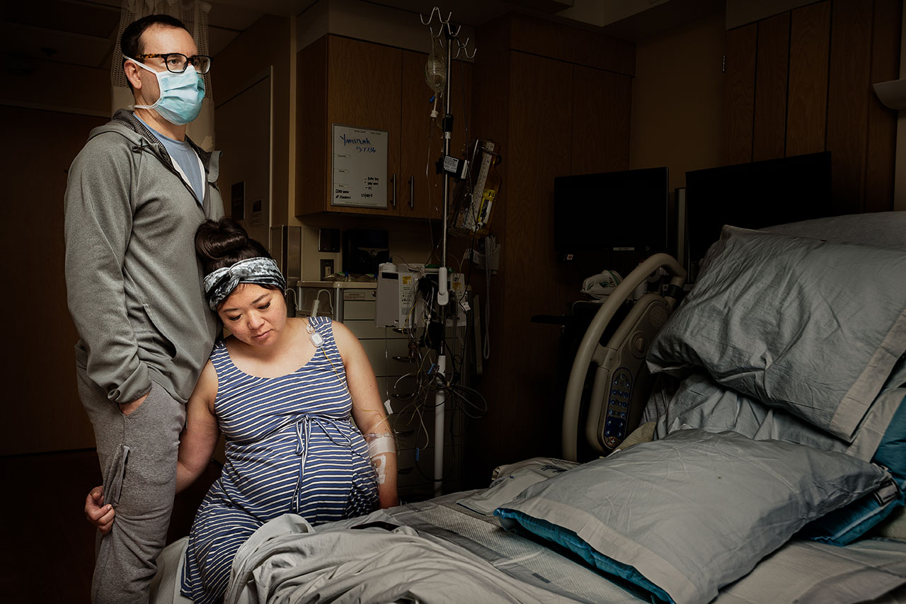 Color birth photo of a woman on a birth ball holding on to her partner