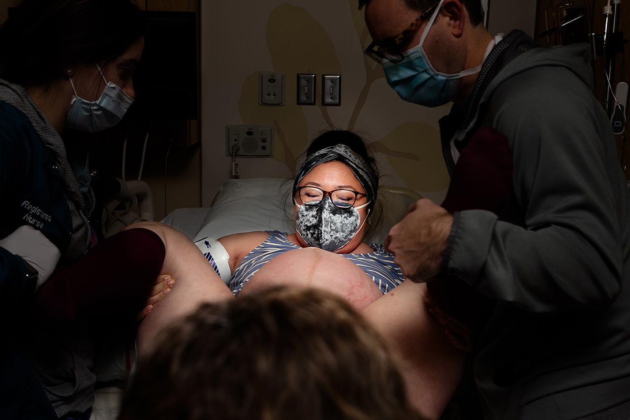 birth photo of a woman pushing during childbirth by Los Angeles birth photographer, Leona Darnell