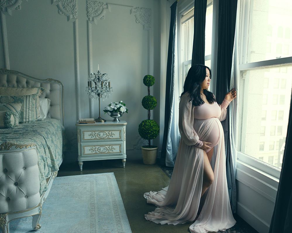 maternity portrait by Leona Darnell showing a pregnant woman gazing out a window