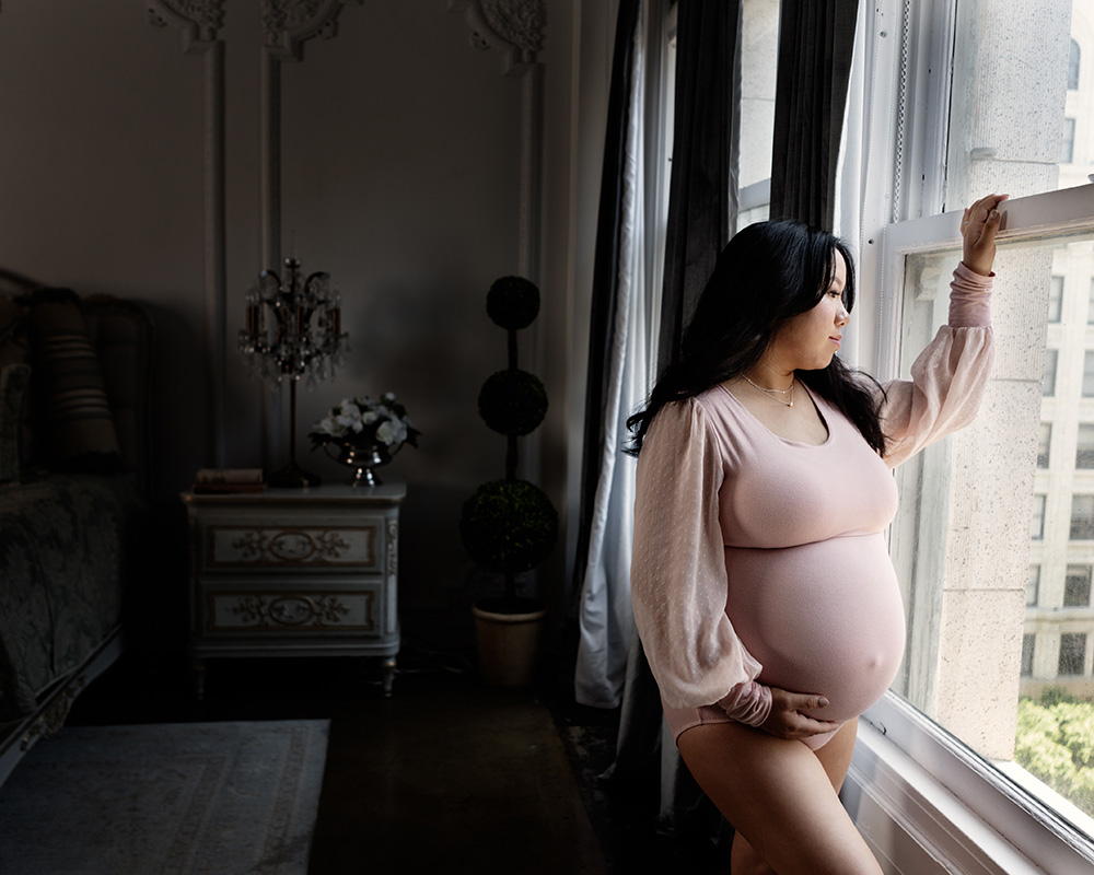 maternity portrait of a pregnant woman in a pink body suit by leona-darnell