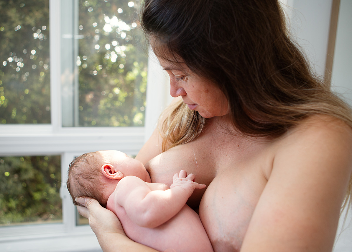 Los Angeles lifestyle newborn photo of a mother nursing her baby.