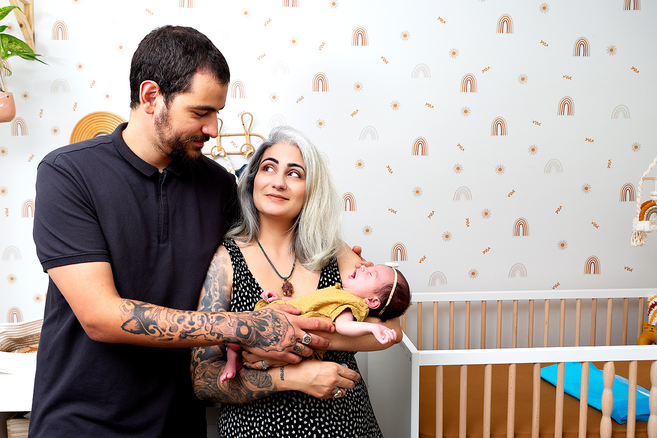 Portrait of a mother, father and newborn daughter in their home by Leona Darnell