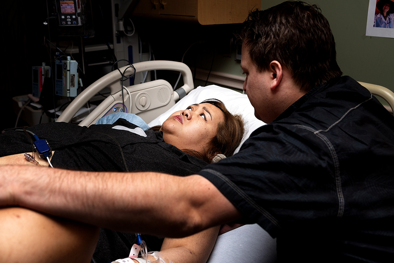 laboring woman in a Pasadena hospital with her husband comforting her.