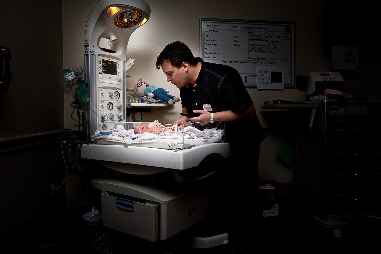 dad looking down on his newborn daughter at Huntington Hospital.