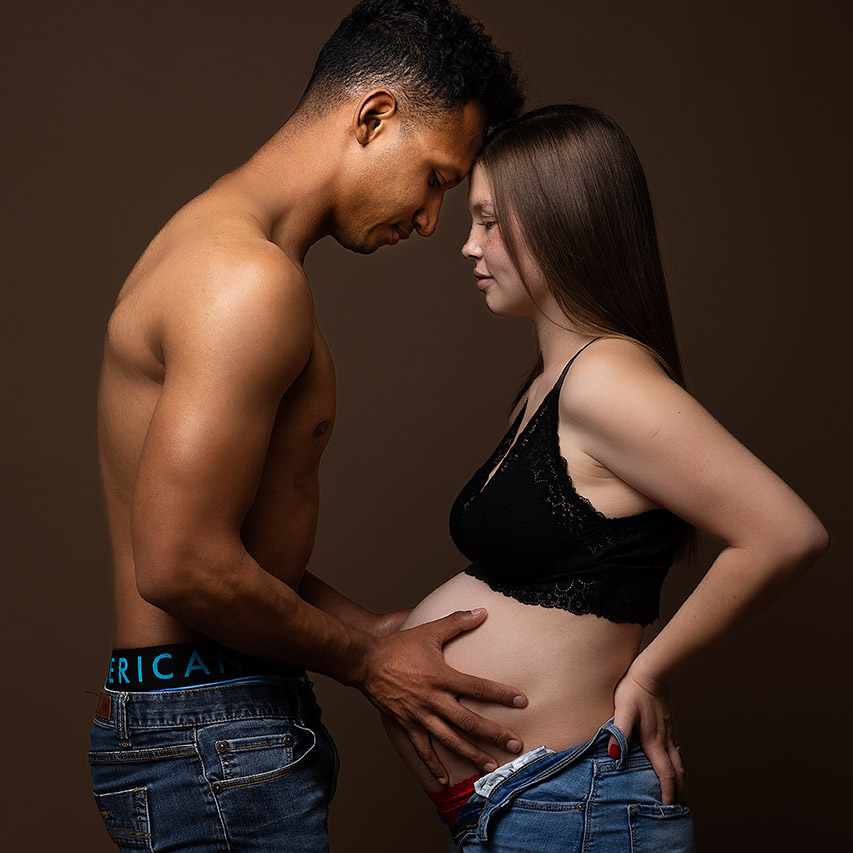 color maternity photo as a mother and the father holding her belly by birth photographer, Leona Darnell