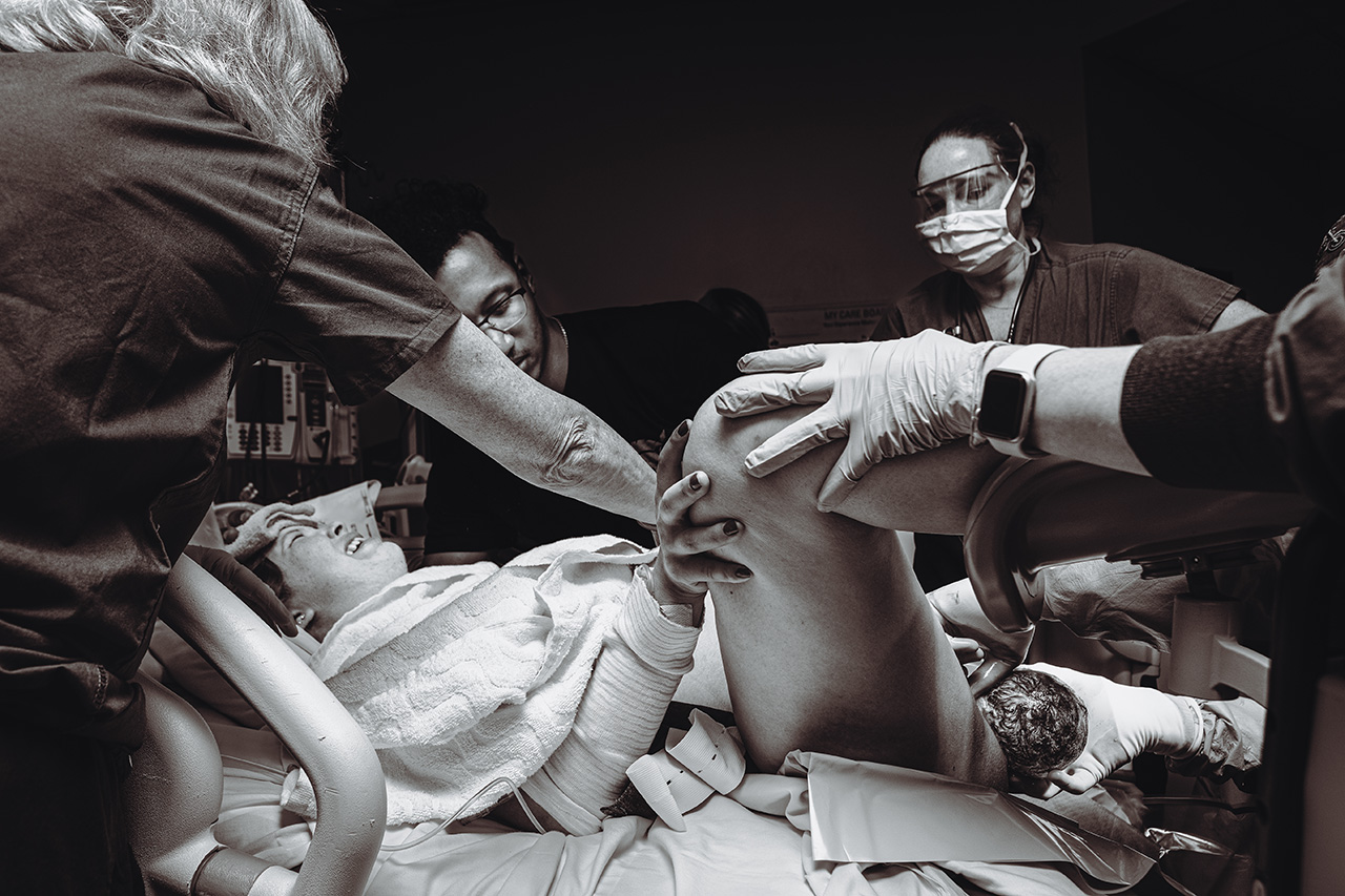 Birth photography black and white image of a mother having a hospital birth by Leona Darnell.