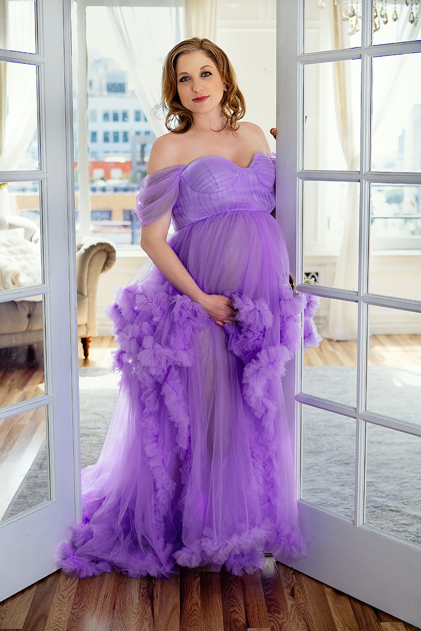 A color maternity photo by Leona Darnell shows a mom-to-be in a purple tulle dress.