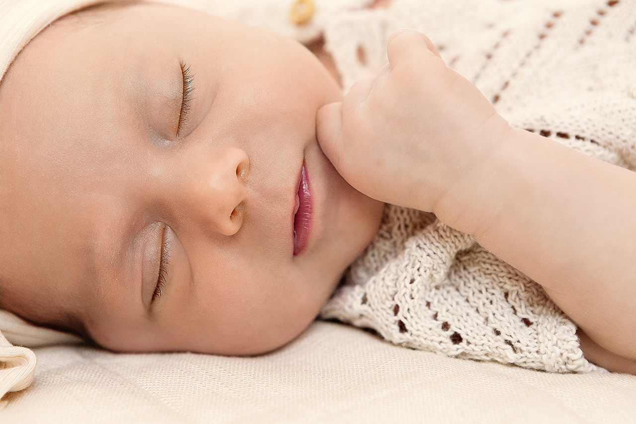 lifestyle newborn picture of a baby girl with her eyes closed by Birth and Beauty