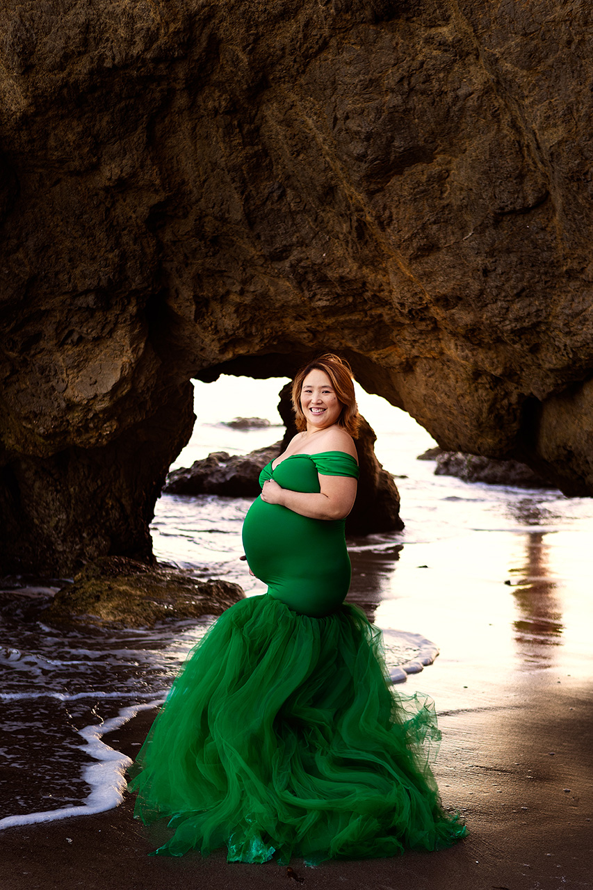 beach maternity photo of a mother to be in a green dress by Leona Darnell