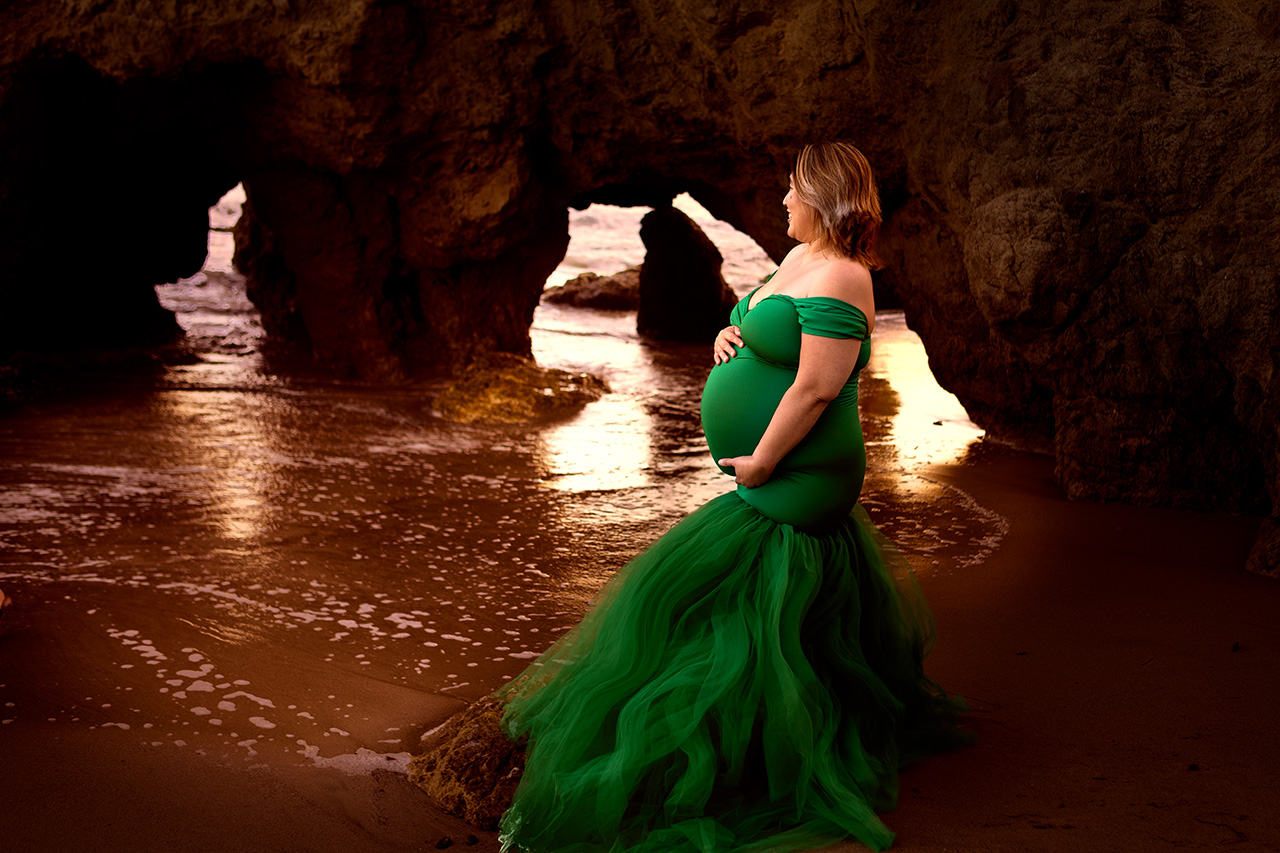 Maternity photoshoot at the beach with mom to be in a green dress.