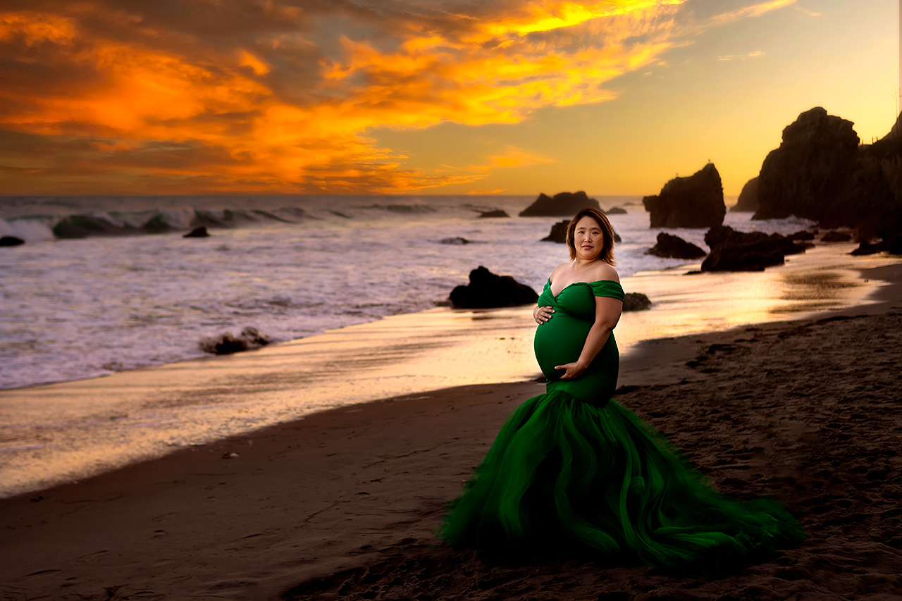 Malibu beach maternity photo of a mother to be in a green dress at sunset by Los Angeles maternity photographer, Leona Darnell.