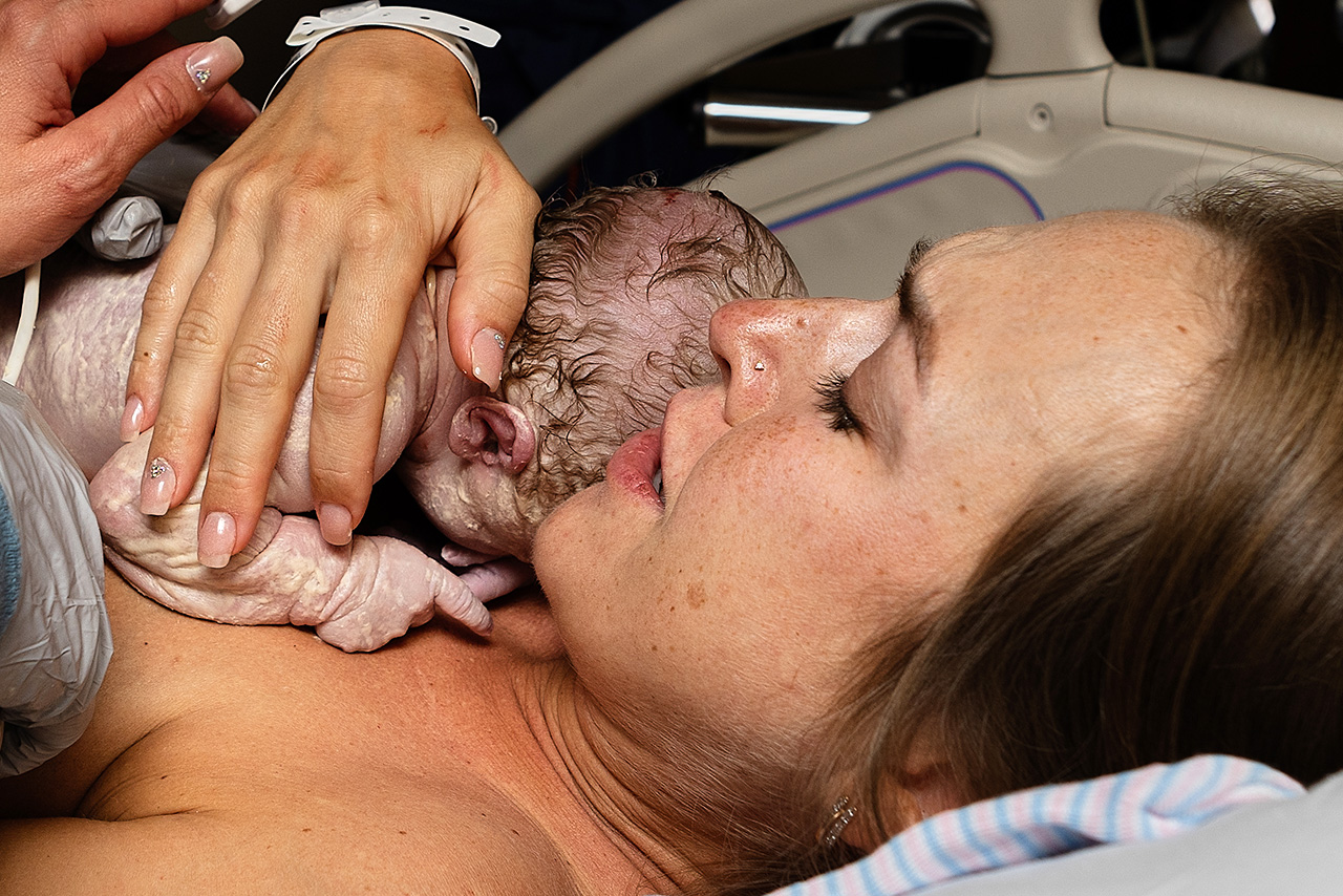 birth photo of a mother holding her daughter for the first time by Birth and Beauty.