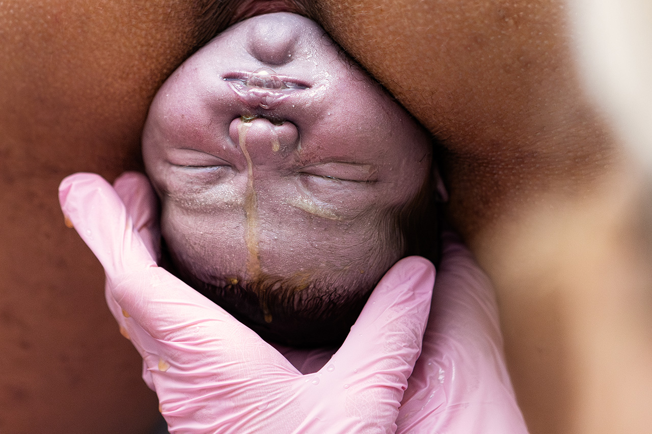 home birth photography image by Leona Darnell of a baby being born.