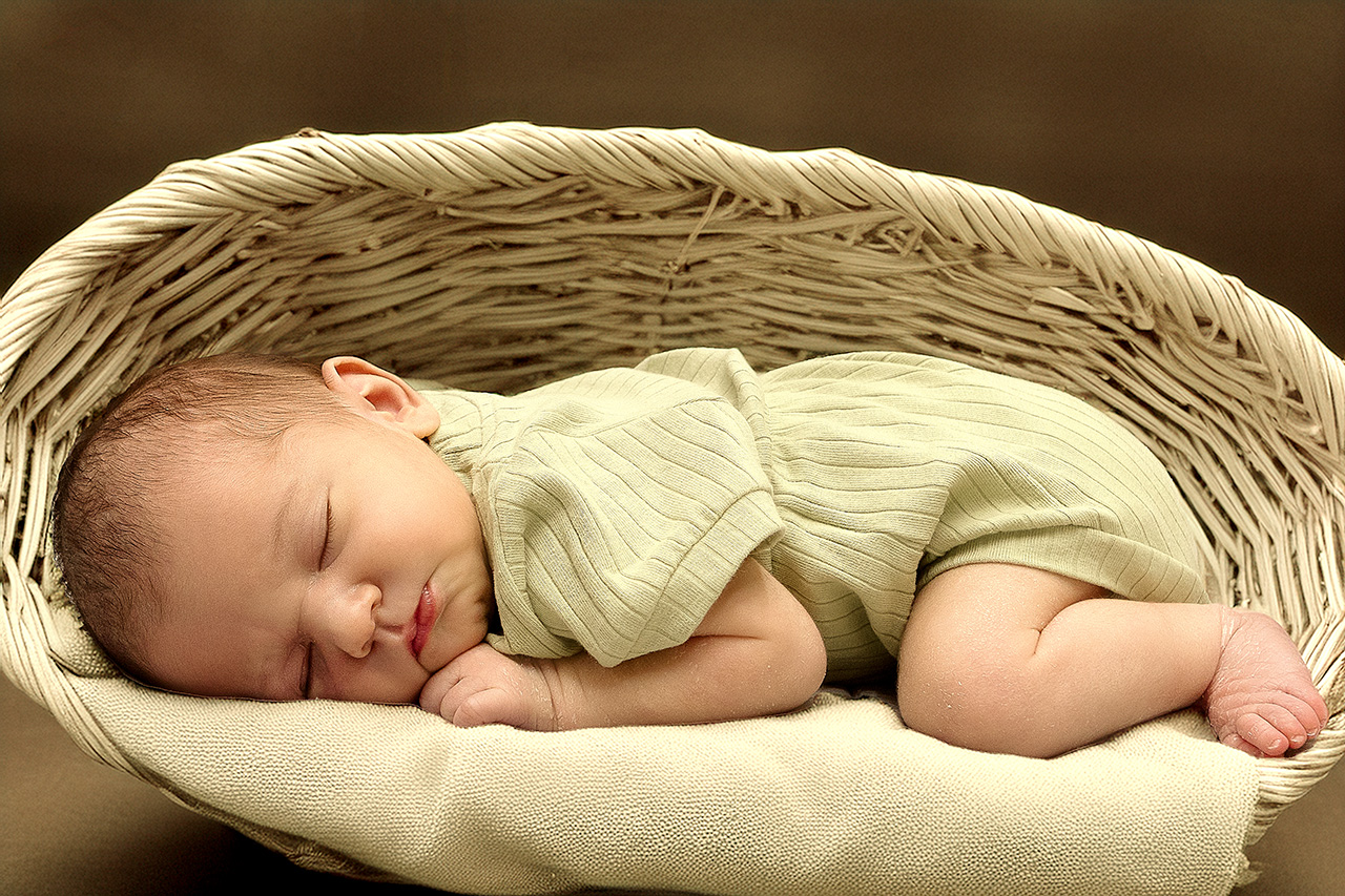 Newborn photo of a baby in a basket.