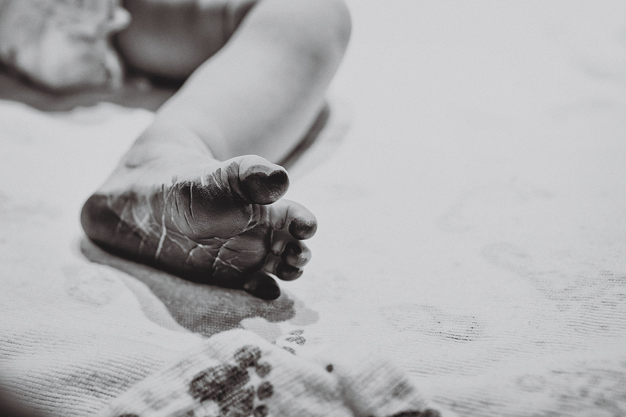 Black and White birth photo of a baby's foot with fresh ink on it by Leona Darnell