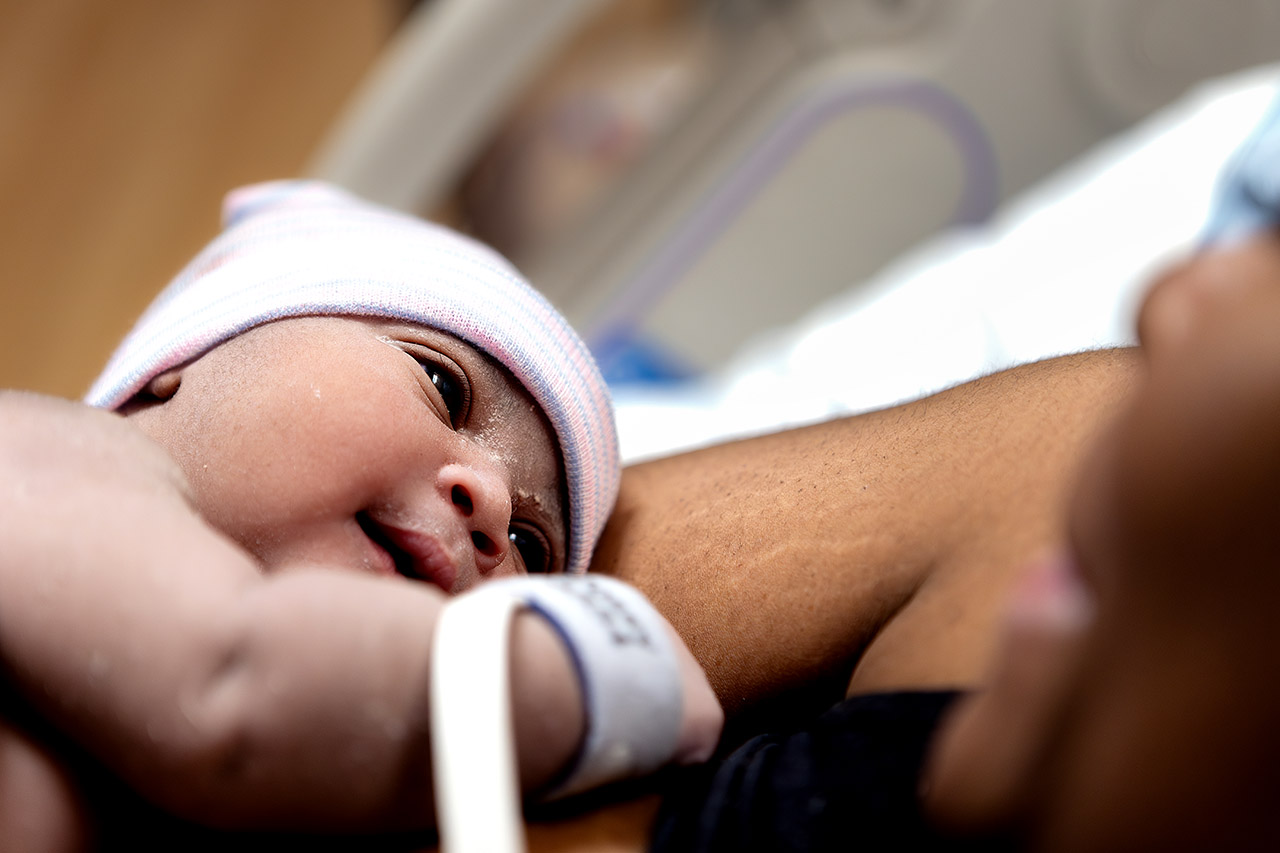 A newborn baby girl looking at her mother for the first time. Photo by Los Angeles birth videographer, Leona Darnell.