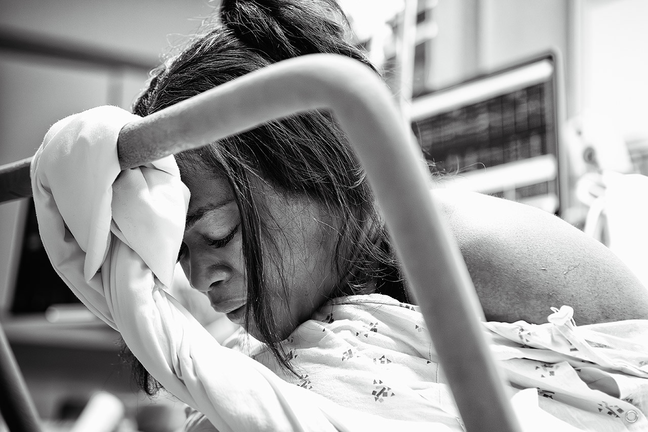 A black and white photo of a woman resting between contractions. Photographer by Los Angeles birth videographer, Leona Darnell.