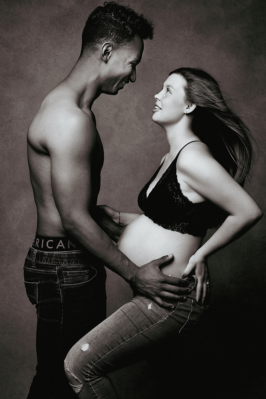 Maternity photo in studio with a man and expectant woman holding each other. Photo by Los Angeles birth and maternity photographer, Leona Darnell 